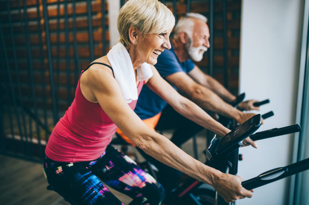 mature man and woman happily exercising together